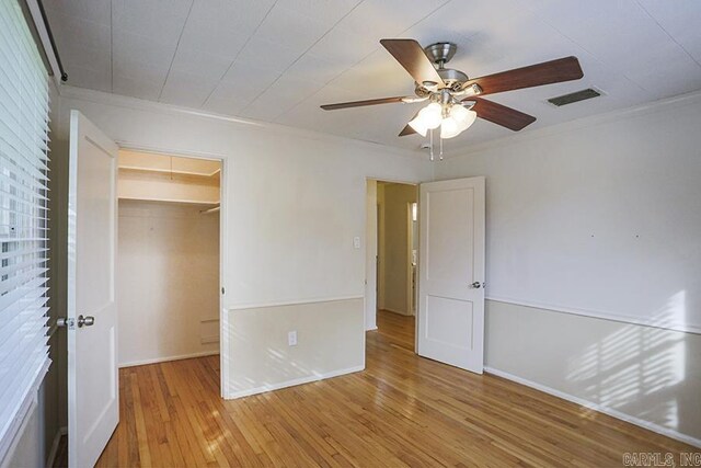 2615 Crouchwood, Little Rock, AR 72207 - unfurnished bedroom featuring hardwood / wood-style floors, crown molding, a walk in closet, a ceiling fan, and a closet