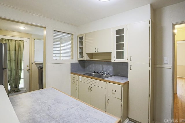 2615 Crouchwood, Little Rock, AR 72207 - kitchen featuring decorative backsplash, glass insert cabinets, and freestanding refrigerator