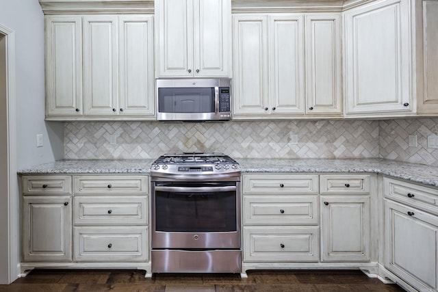2300 Gordon Rd, Little Rock, AR 72223 - kitchen featuring appliances with stainless steel finishes, tasteful backsplash, light stone countertops, and white cabinets