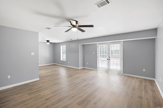 empty room with a ceiling fan, french doors, and wood finished floors