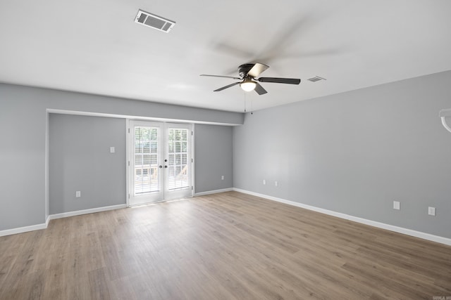 spare room featuring a ceiling fan, wood finished floors, and french doors