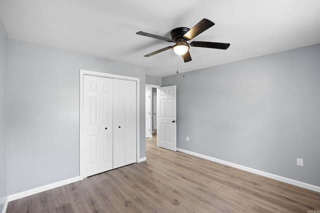 unfurnished bedroom featuring wood finished floors, a closet, and ceiling fan