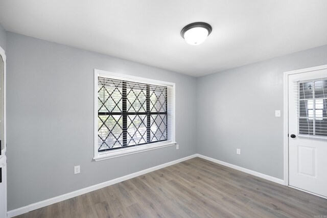 spare room featuring wood finished floors and baseboards
