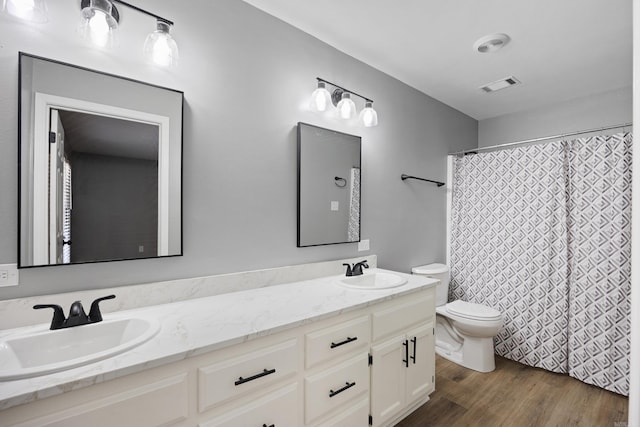 full bathroom with double vanity, wood finished floors, and curtained shower