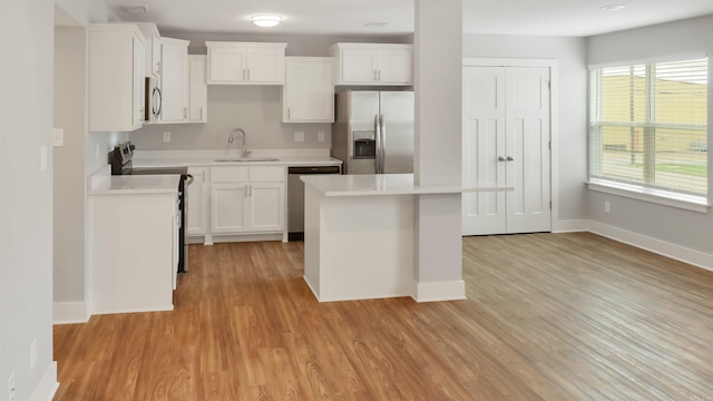 300 W Pleasure Ave, Searcy, AR 72143 - kitchen with appliances with stainless steel finishes, light countertops, light wood-type flooring, and a center island