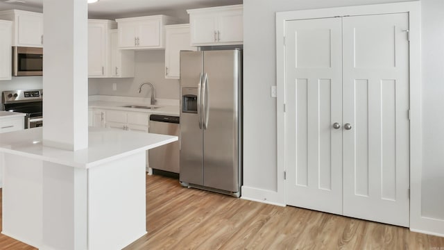 300 W Pleasure Ave, Searcy, AR 72143 - kitchen featuring stainless steel appliances, light wood-type flooring, white cabinets, light countertops, and a kitchen island