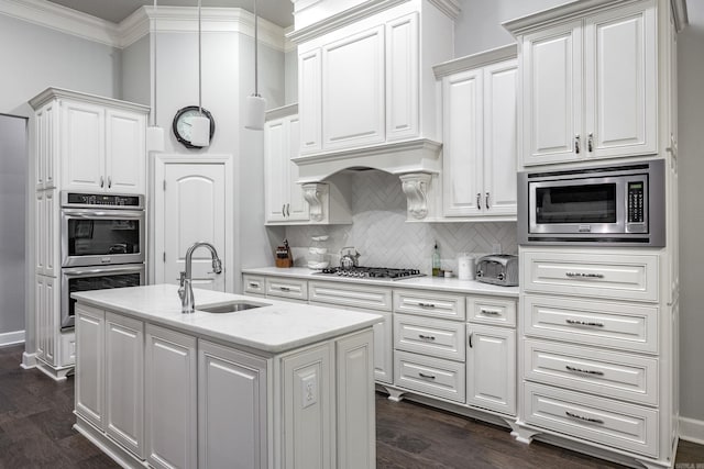 21 Ensbury Pl, Little Rock, AR 72223 - kitchen featuring stainless steel appliances, tasteful backsplash, white cabinets, a center island with sink, and ornamental molding