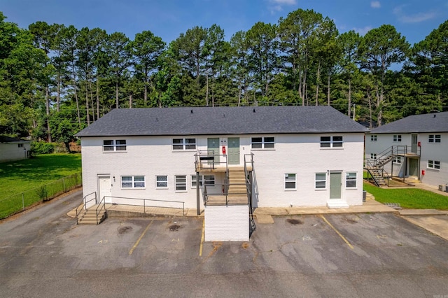 709 Melody Ln, Searcy, AR 72143 - rear view of house with stairs, uncovered parking, and view of scattered trees