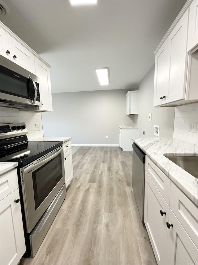 709 Melody Ln, Searcy, AR 72143 - kitchen featuring appliances with stainless steel finishes, light stone counters, tasteful backsplash, and white cabinets