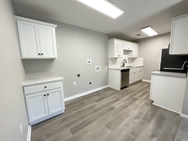 709 Melody Ln, Searcy, AR 72143 - laundry room with electric dryer hookup, light wood-type flooring, gas dryer hookup, washer hookup, and cabinet space