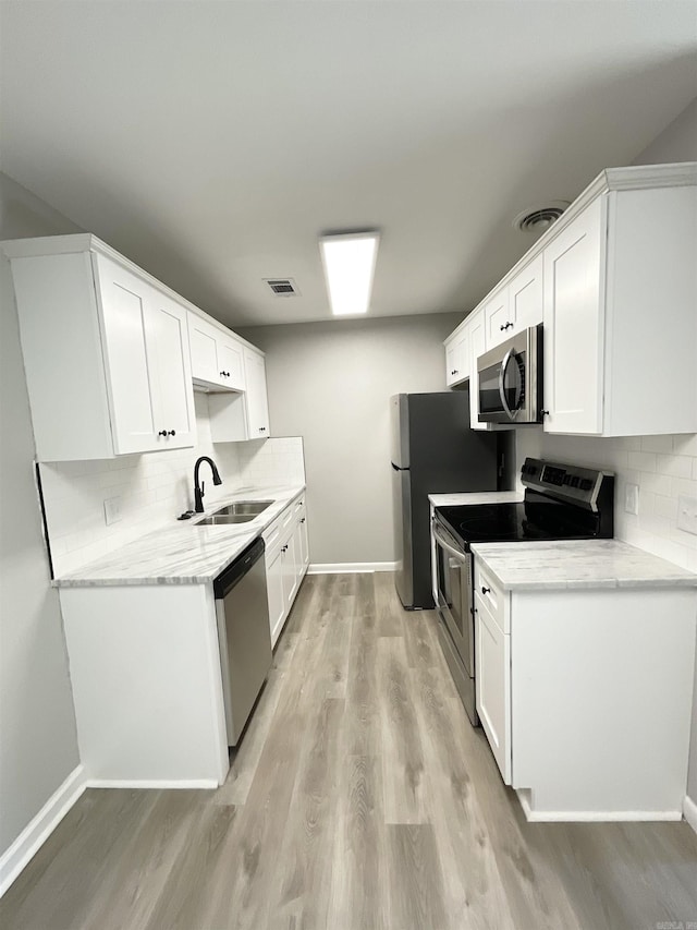 709 Melody Ln, Searcy, AR 72143 - kitchen with appliances with stainless steel finishes, light wood-type flooring, and tasteful backsplash