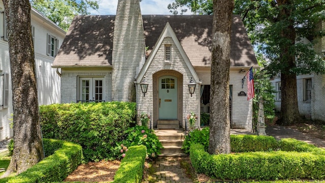 1811 N Jackson St, Little Rock, AR 72207 - tudor-style house featuring brick siding, a chimney, and a shingled roof