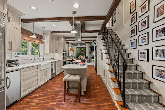 1811 N Jackson St, Little Rock, AR 72207 - kitchen featuring stainless steel appliances, backsplash, light countertops, brick floors, and a center island