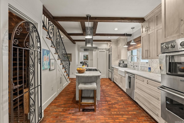 1811 N Jackson St, Little Rock, AR 72207 - kitchen featuring appliances with stainless steel finishes, decorative backsplash, a center island, brick flooring, and beam ceiling