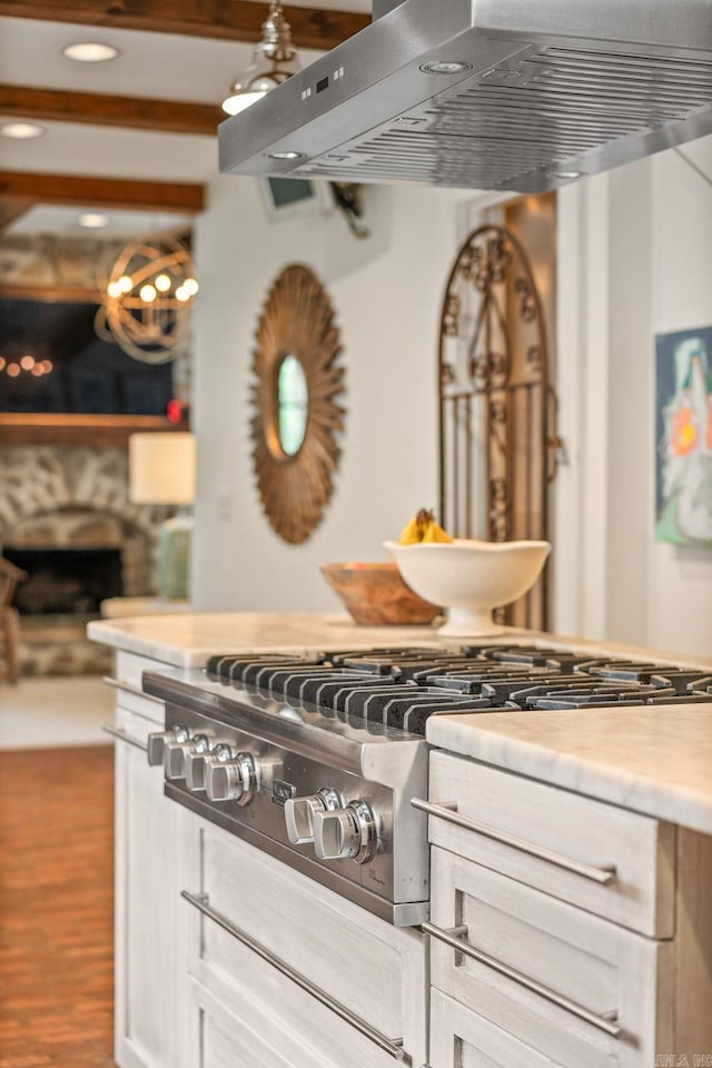 1811 N Jackson St, Little Rock, AR 72207 - kitchen with extractor fan, a fireplace, wood finished floors, light countertops, and stainless steel gas stovetop