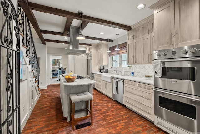 1811 N Jackson St, Little Rock, AR 72207 - kitchen with appliances with stainless steel finishes, island range hood, tasteful backsplash, a kitchen island, and brick patterned flooring