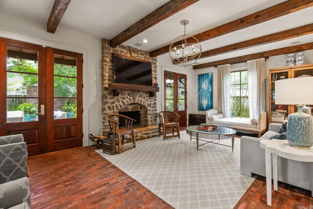 1811 N Jackson St, Little Rock, AR 72207 - living room featuring a chandelier, brick floors, beam ceiling, and a stone fireplace