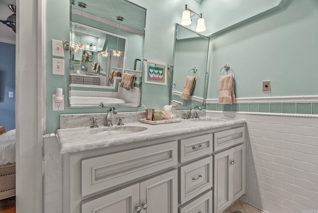 1811 N Jackson St, Little Rock, AR 72207 - full bathroom featuring ensuite bathroom, tile walls, double vanity, wainscoting, and a bath