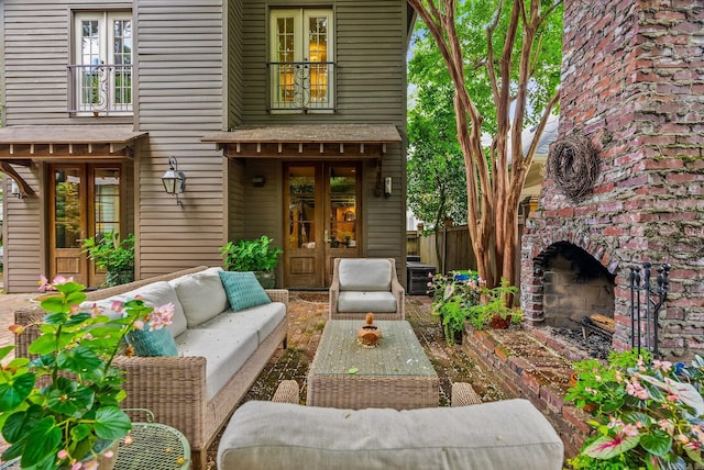 1811 N Jackson St, Little Rock, AR 72207 - view of exterior entry with french doors and an outdoor living space with a fireplace
