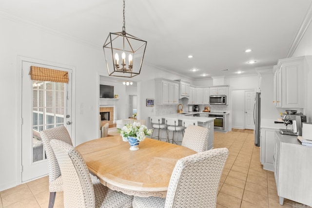 7 Chalamont Way, Little Rock, AR 72223 - dining space with light tile patterned floors, a chandelier, crown molding, recessed lighting, and a fireplace