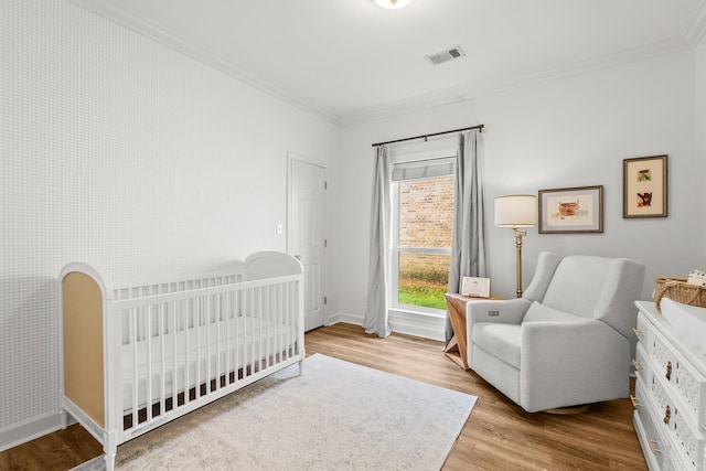 7 Chalamont Way, Little Rock, AR 72223 - bedroom featuring crown molding, wood finished floors, and a nursery area