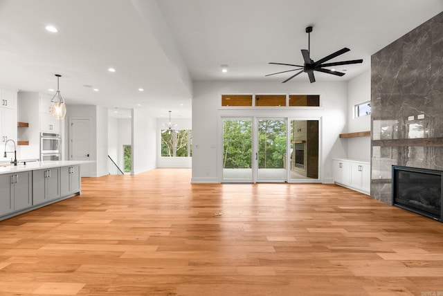 41 Haywood Ct, Little Rock, AR 72223 - unfurnished living room with ceiling fan, a tile fireplace, light wood-style flooring, recessed lighting, and healthy amount of natural light