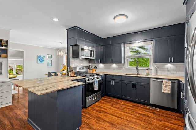 7002 Amherst Dr, Little Rock, AR 72205 - kitchen featuring appliances with stainless steel finishes, a peninsula, decorative backsplash, light stone counters, and dark wood-style flooring