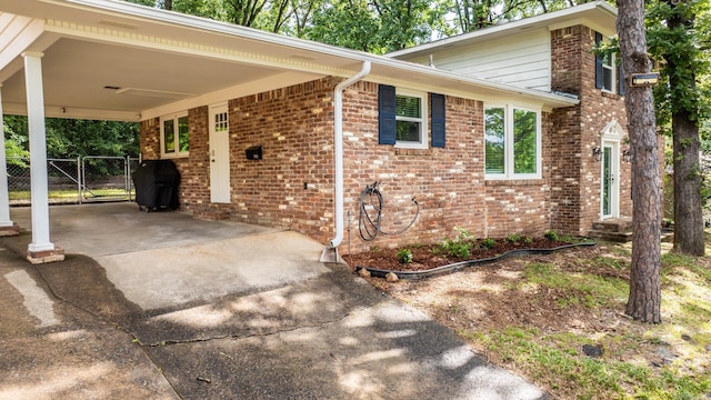 7002 Amherst Dr, Little Rock, AR 72205 - view of side of home featuring concrete driveway, an attached carport, brick siding, and a gate