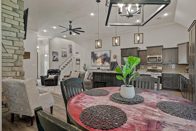 2720 Paradise Hls, Jonesboro, AR 72405 - dining area with wood finished floors, ceiling fan, stairs, crown molding, and high vaulted ceiling