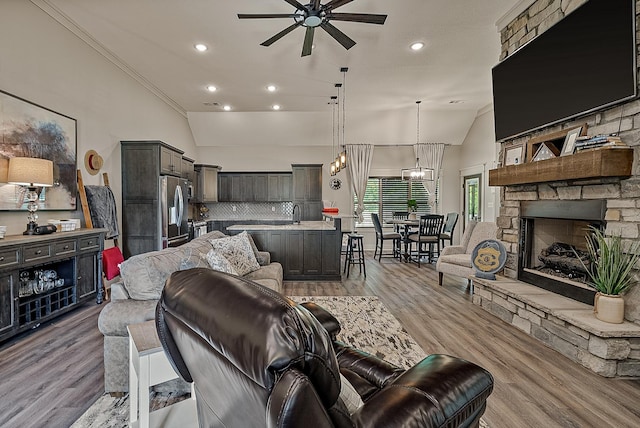 2720 Paradise Hls, Jonesboro, AR 72405 - living room featuring ceiling fan, light wood-style flooring, vaulted ceiling, recessed lighting, and a stone fireplace
