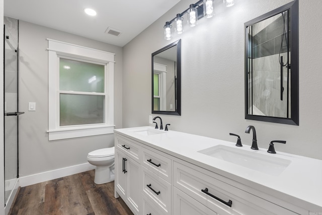 26 W Mobbs Cir, Greenbrier, AR 72058 - bathroom featuring double vanity, tiled shower, and wood finished floors