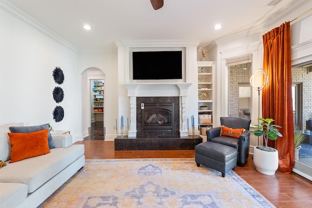 5090 Oakhurst Way, Conway, AR 72034 - living area featuring a premium fireplace, wood finished floors, ornamental molding, arched walkways, and recessed lighting