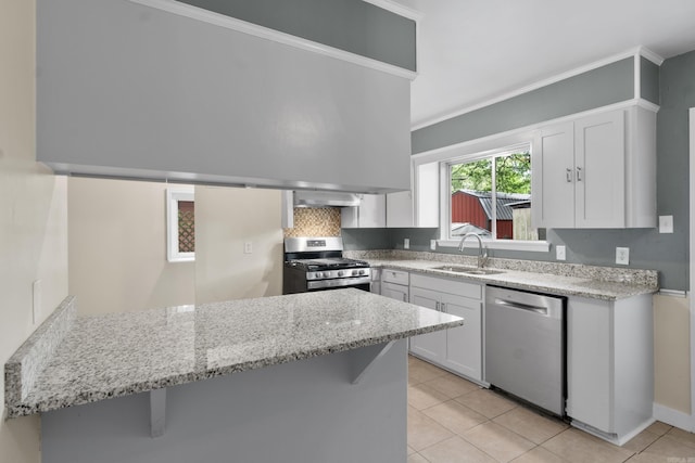 9317 Cynthia Dr, Little Rock, AR 72204 - kitchen featuring stainless steel appliances, a peninsula, light stone countertops, light tile patterned flooring, and ornamental molding