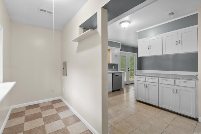 9317 Cynthia Dr, Little Rock, AR 72204 - kitchen with stainless steel dishwasher, white cabinets, light tile patterned floors, and light stone counters
