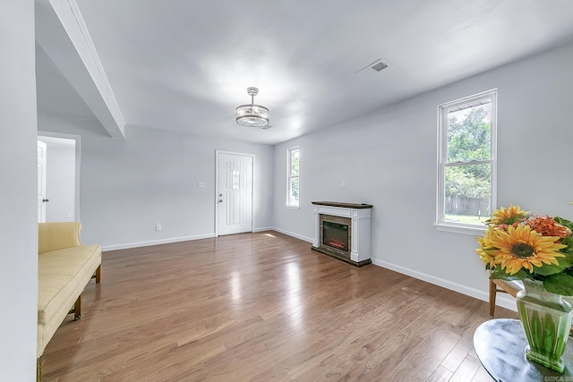 1550 E Main St, Austin, AR 72007 - unfurnished living room featuring wood finished floors, a lit fireplace, and a chandelier