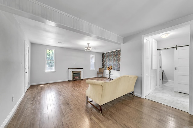 1550 E Main St, Austin, AR 72007 - living room featuring a barn door, wood finished floors, and a glass covered fireplace