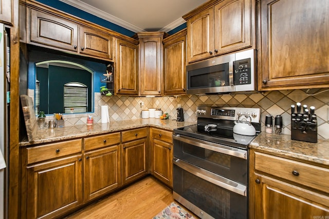 3200 Overcup Dr, Sherwood, AR 72120 - kitchen with appliances with stainless steel finishes, ornamental molding, light wood finished floors, tasteful backsplash, and light stone countertops
