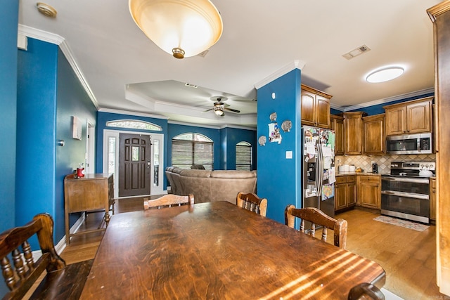 3200 Overcup Dr, Sherwood, AR 72120 - dining room with ornamental molding, light wood-style flooring, a tray ceiling, and a ceiling fan