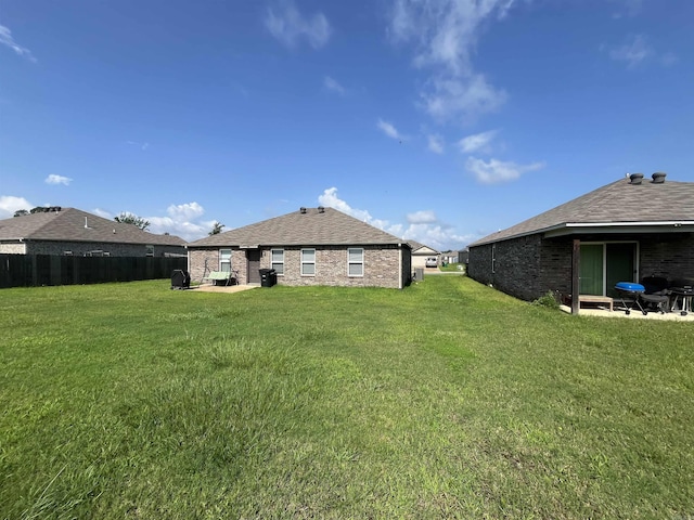 rear view of house featuring brick siding and a shingled roof
