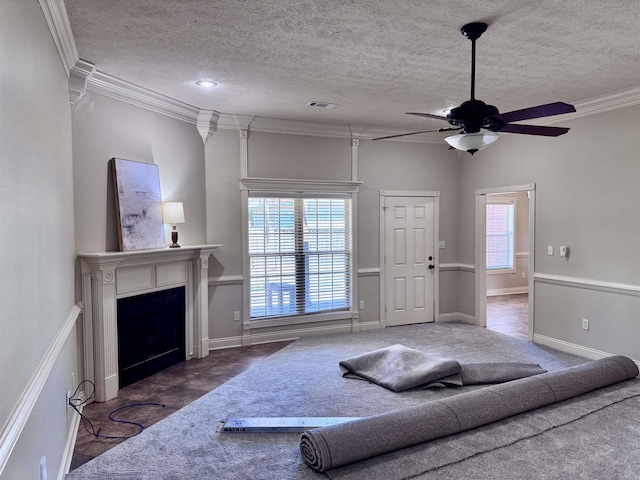 carpeted living room with a textured ceiling, ceiling fan, a fireplace, and ornamental molding
