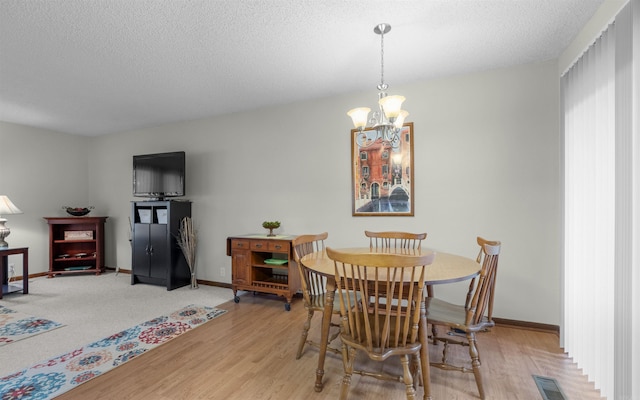 5 Torre Del Mar Way, Hot Springs Village, AR 71909 - dining area featuring a chandelier, light wood-style flooring, and a textured ceiling