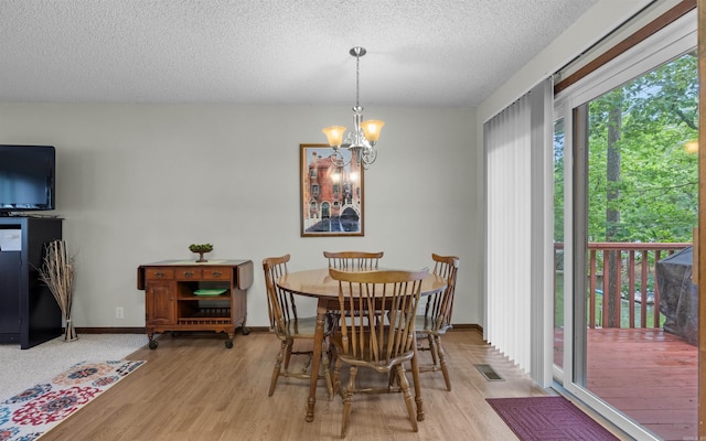 5 Torre Del Mar Way, Hot Springs Village, AR 71909 - dining space featuring light wood-style flooring, a chandelier, and a textured ceiling