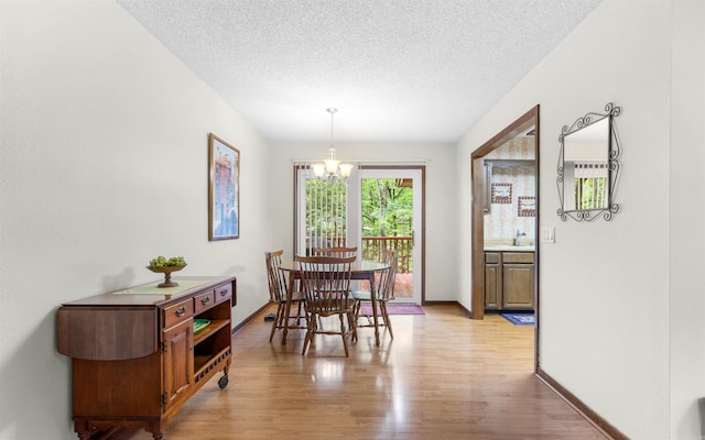 5 Torre Del Mar Way, Hot Springs Village, AR 71909 - dining space with a chandelier, light wood-style floors, and a textured ceiling
