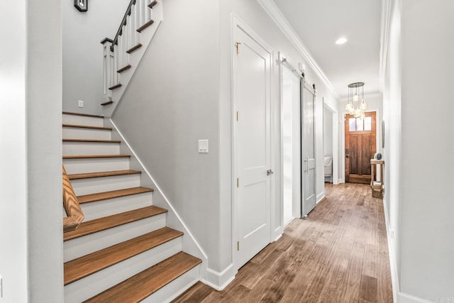 301 Kanis Ridge Dr, Little Rock, AR 72223 - staircase featuring a barn door, wood finished floors, ornamental molding, a chandelier, and recessed lighting