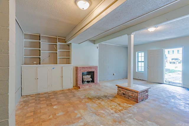1304 Dupwe Dr, Jonesboro, AR 72401 - unfurnished living room with a textured ceiling and a brick fireplace