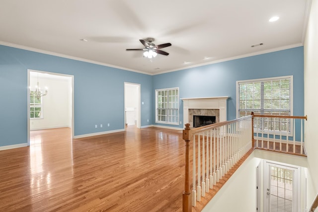 2219 Westport Loop, Little Rock, AR 72212 - unfurnished living room with wood finished floors, ceiling fan, a tile fireplace, ornamental molding, and a chandelier