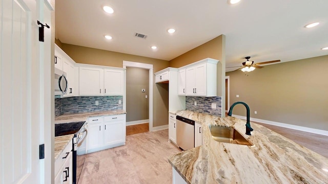 56 Blair, Vilonia, AR 72173 - kitchen with appliances with stainless steel finishes, decorative backsplash, light stone countertops, ceiling fan, and white cabinetry