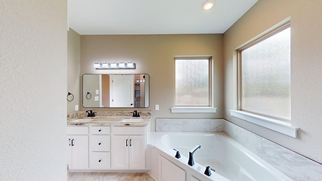 56 Blair, Vilonia, AR 72173 - full bathroom featuring double vanity, a bath, and a textured wall