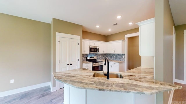56 Blair, Vilonia, AR 72173 - kitchen with appliances with stainless steel finishes, a peninsula, tasteful backsplash, light stone countertops, and white cabinets