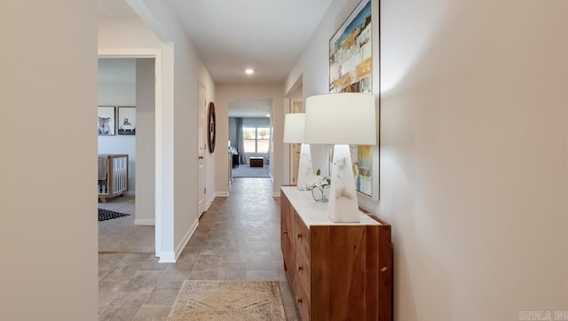 hall featuring recessed lighting and baseboards